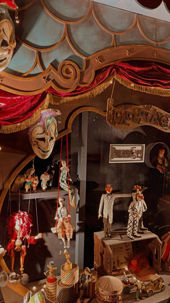 Diorama de circo vintage com marionetes, cortinas vermelhas e ornamentos dourados